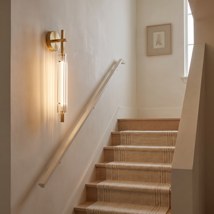 Calderra wall sconce on a staircase wall beside pale oak treads